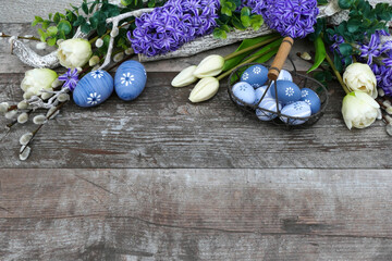  Ostereier mit Tulpen und Hyazinthen auf einem Holzhintergrund mit Platz für Text.