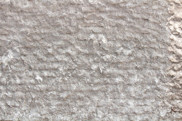 Rough plaster wall with small patterns shown on a wall. Grey plaster texture background 