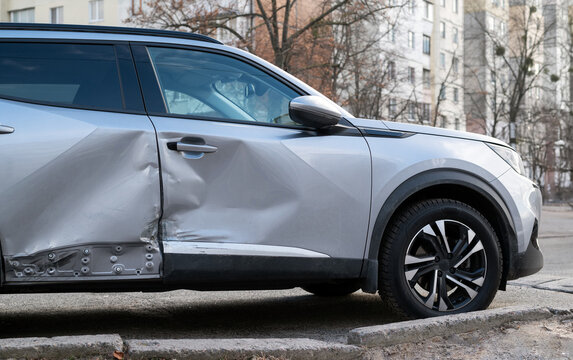 Damage to a gray modern stylish car from the body and doors after an accident.