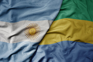 big waving national colorful flag of gabon and national flag of argentina .