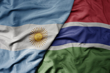 big waving national colorful flag of gambia and national flag of argentina .