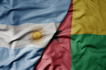 big waving national colorful flag of guinea bissau and national flag of argentina .