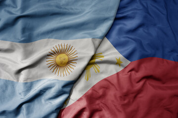 big waving national colorful flag of philippines and national flag of argentina .