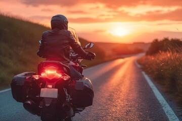 A lone rider cruises along the open road on their motorcycle, the fiery sunset painting the sky as they feel the freedom and thrill of the journey ahead - obrazy, fototapety, plakaty