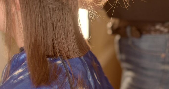 Young woman undergoing a style transformation at the hair salon. Skilled hairstylist changing her hairstyle to enhance her self-assurance. People confidence through personalized style transformation.