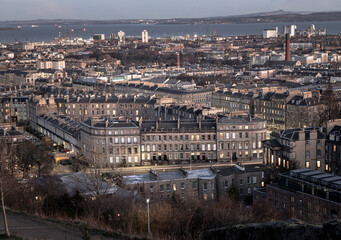 Fototapeta premium Cityscape view of Edinburgh towards Leith Docks and the Firth of Forth from Calton Hill in central Edinburgh. Destinations in Europe, Space for text, Selective focus.