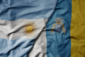 big waving national colorful flag of canary islands and national flag of argentina .