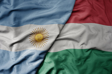 big waving national colorful flag of hungary and national flag of argentina .