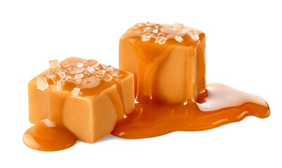 Two salty caramel candy cubes topped with caramel sauce and salt on white background - obrazy, fototapety, plakaty