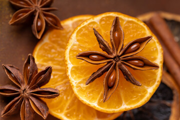 top view, in the foreground, a star of star anise laid on orange slices