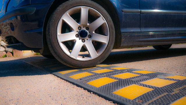 car passing over a speed bump in the foreground. shock absorbers and tires that strain. possible accident and material damage.