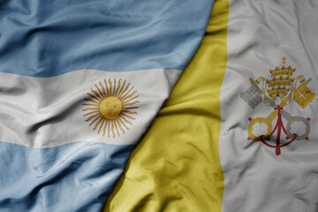 big waving national colorful flag of vatican city and national flag of argentina .