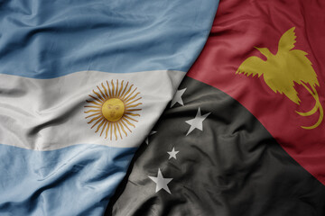 big waving national colorful flag of Papua New Guinea and national flag of argentina .
