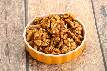 Cracked unshelled walnut in the bowl