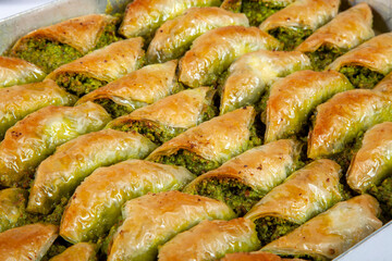 Top view of shaabiyat with pistachio baklava on tray isolated on white background.