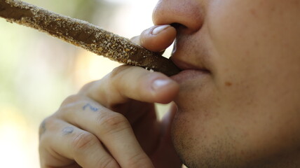 a person with a breaded marijuana blunt in outdoor park