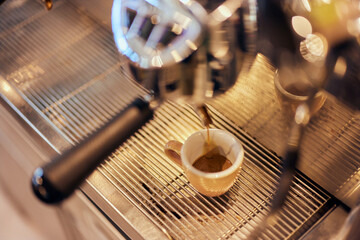 Top view of a coffee machine pouring an espresso into the cup.