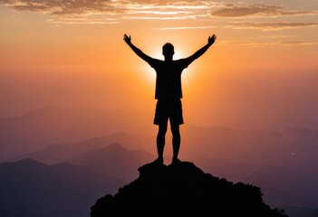 Fototapeta premium A silhouette of a man standing victorious on the peak of a mountain