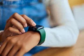 Fotobehang Close-up of a black female using a smartwatch, wearing around the wrist. © bnenin