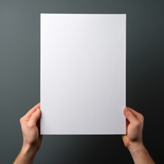 A woman's hand holding a blank paper on a grey background.