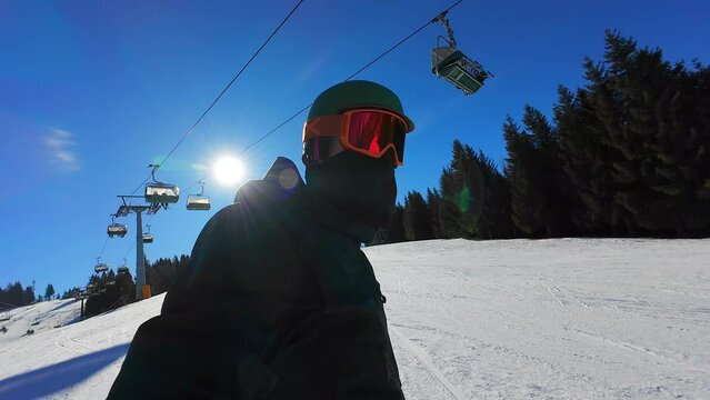 SLO MO Snowboarder making selfie video while snowboarding on a sunny winter day