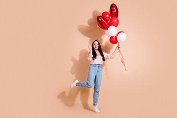 Full size photo of impressed astonished woman dressed silk blouse hold helium bubbles on valentine day isolated on beige color background