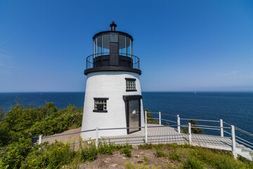 Fototapeta na wymiar Owls Head Lighthouse in Rockland Maine USA on a clear sunny summer day with blue sky