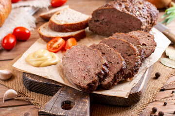 Fototapeta na wymiar Traditional baked meatloaf slices on wooden table. Sekana Pecene - Czech Meatloaf