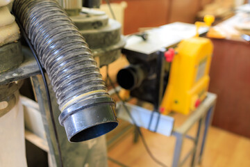 Pipe of an industrial vacuum cleaner in the workshop. Background with selective focus and copy space