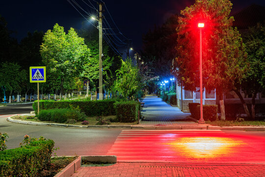 Night red illumination of a pedestrian crossing. Background with selective focus and copy space