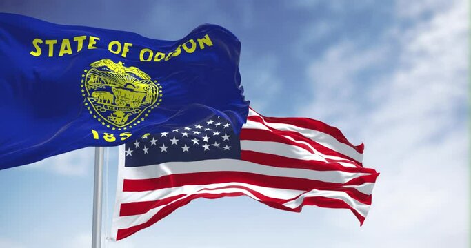 Oregon state flag waving with the american flag on a clear day
