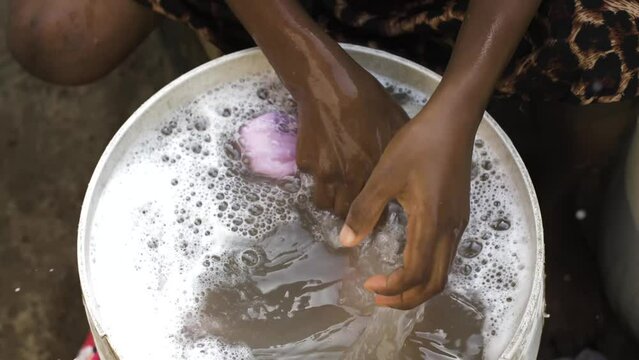9 jan. 2024,Gwalada,Nigeria: African black girl  living in a rural villages washing her clothes in rural village settlement, villagers uses river stream water for washing by hand