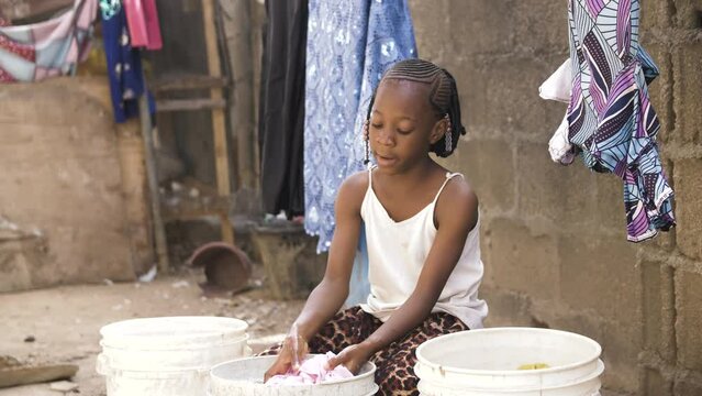9 jan. 2024,Gwalada,Nigeria: African black girl  living in a rural villages washing her clothes in rural village settlement, villagers uses river stream water for washing by hand