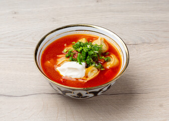 Uzbek chuchvara soup in a traditional plate on a wooden background