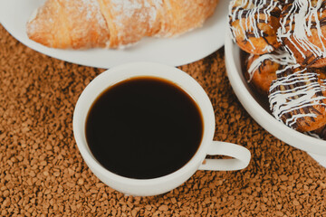A cup of instant coffee granules and scones. Beautiful and delicious breakfast.