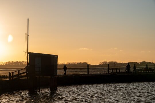 wooden observation bird hide on brick stilts at Emsworth at sunset with orange coloured sky in the background