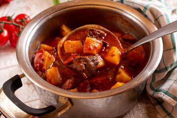 Goulash or Gulasch is a soup or stew of meat, potatoes and vegetables seasoned with paprika and other spices. Perfect for recipe, menu book, or any cooking contents.