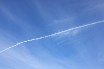 background is a blue sky with a light cloudy haze and a trace of a plane that flew away