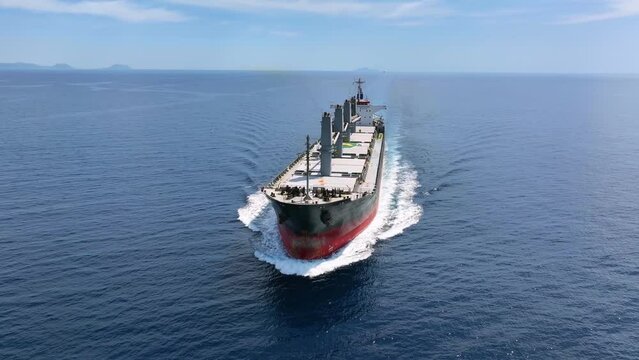 Aerial view of a bulk carrier cargo vessel traveling with high speed over blue sea as a concept for import and export industry