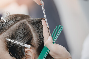 Concept Barbershop for man. Closeup master hairdresser does hairstyle and style with scissors and...