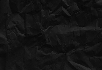 close up texture of dark black crumpled or torn craft paper use as background with blank space for...