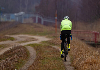 Cyclist riding mountain bike on rural road. Sport fitness and healthy lifestyle.