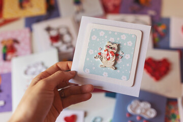 Hand holding quilling card with cute cat with hearts. Love concept. Happy valentine day, dating,romantic or wedding. making greeting cards. Hand made of paper quilling technique. Handicraft at home.