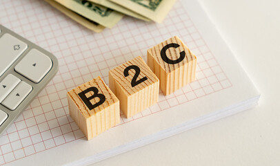 Wooden Blocks with B2C Text on Notebook with Calculator and Money. Business Relations Concept.