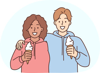 Smiling interracial couple hug eating ice cream together. Happy man and woman embrace enjoy romantic date outdoors. Friendship and relationship.