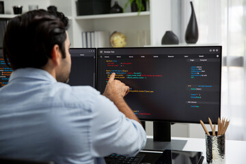 Concentrating in smart IT developer working software development coding on two pc screen, creating...