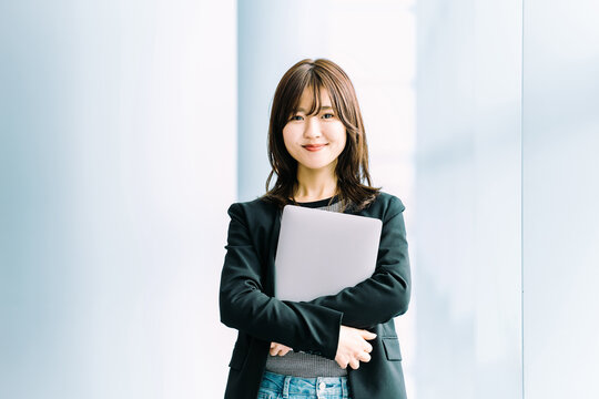 ノートパソコンを持つビジネスウーマン, Smiling Japanese woman holding a laptop computer
