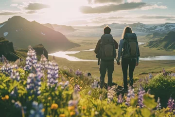 Zelfklevend Fotobehang A couple of young hikers with heavy backpacks admiring scenic view of spectacular Icelandic nature. Breathtaking landscape of Iceland. Hiking by foot. © MNStudio