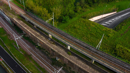 Aerial view on many train tracks. Under the tracks a bridge with a city street.