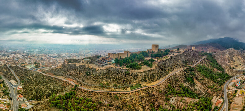 Aerial panorama of Lorca medieval castle with dramatic stormy sky